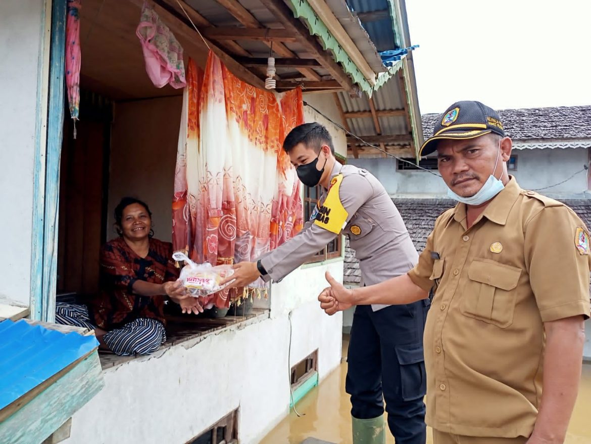 Dampingi Kades Bagikan Sembako ke Warga Korban Banjir, Bhabinkamtibmas Polsek Ella Hilir Juga Imbau Kamtibmas Kewarganya