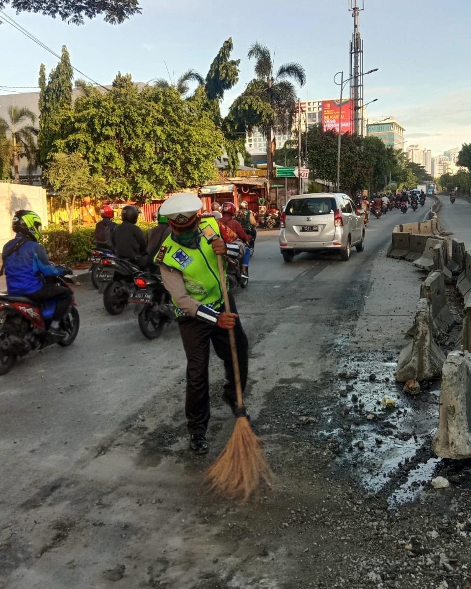 Personel Satlantas Palmerah Jakbar Melakukan Pembersihan Sejumlah Oli Yang Tercecer Di Jalan