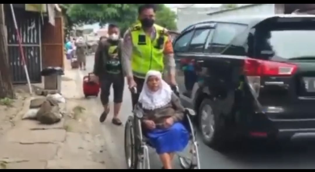 Aksi Mulia Personel Sat Lantas kembangan Jakarta Barat Membantu Mendorong kan Kursi Roda Seorang Ibu Yang Akan Naik Kendaraan Bus Di Jalan Raya kembangan Jakarta Barat, Jumat, 28/1/2022