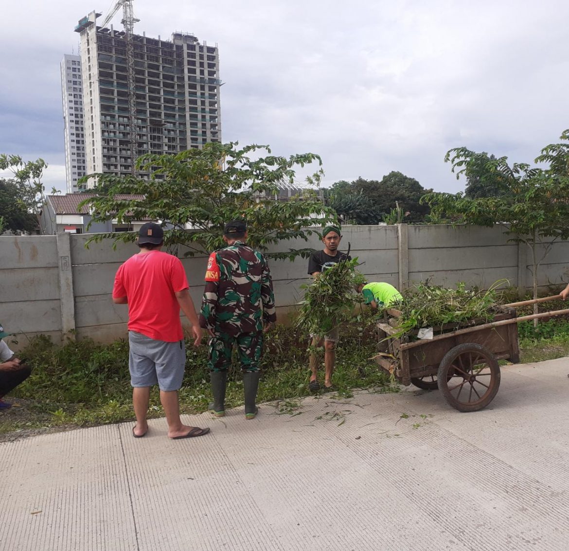 Bersama Warga, Babinsa Bersihkan Rumput Liar di Pinggir Jalan