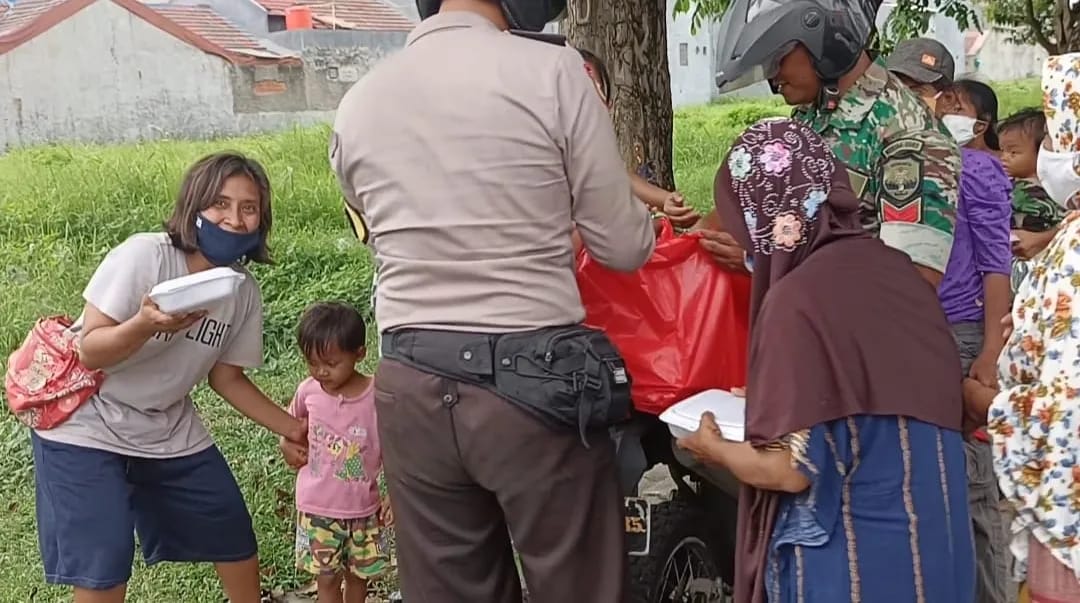 Babinsa Koramil 03/Teluk Pucung Bersama Bhabinkamtibmas Bagikan Nasi Kotak Kepada Warga Kurang Mampu