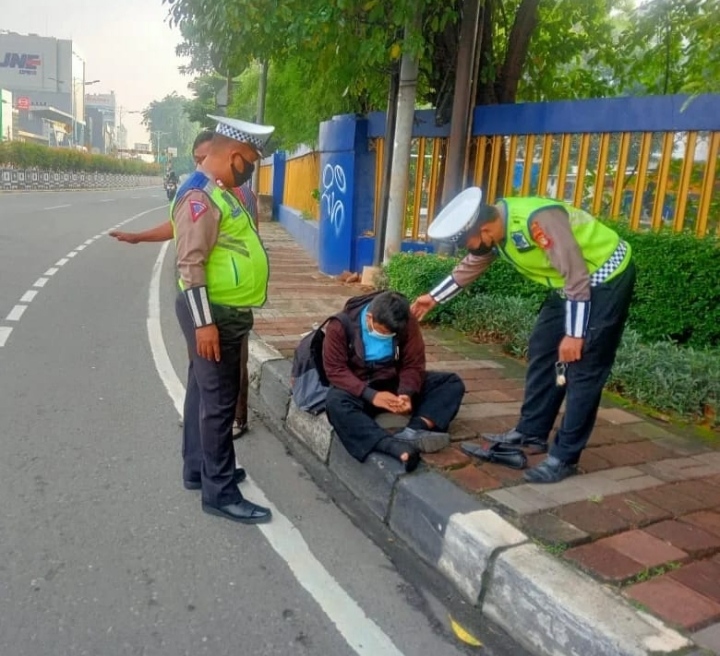 Anggota Satlantas Jakarta Barat Membantu Pengendara Sepeda Motor Yang Tiba Tiba Pingsan Di jalan