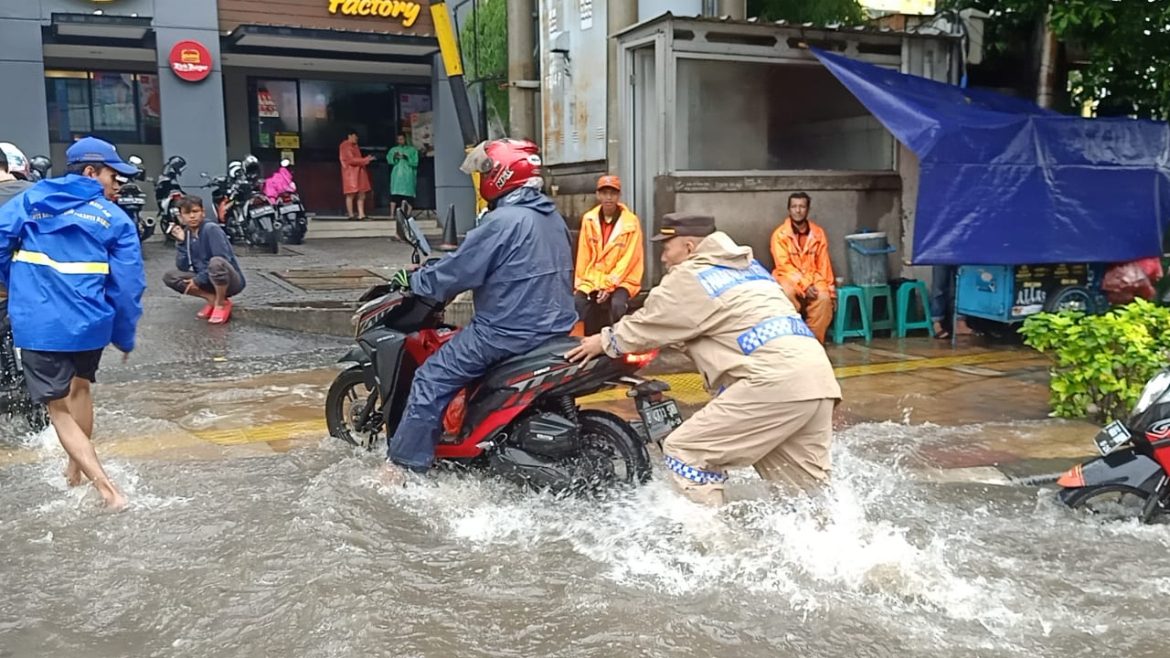 Bhabinkamtibmas Polsek Tanjung Duren Jakarta Barat Sigap Membantu Warga Yang Mengalami Kendaraan Mogok Akibat Genangan Banjir Hujan