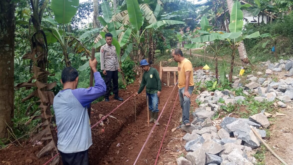 Bhabinkamtibmas Polsek Cisaga Monitoring Pembangunan Drainase di Dusun Sukajaya