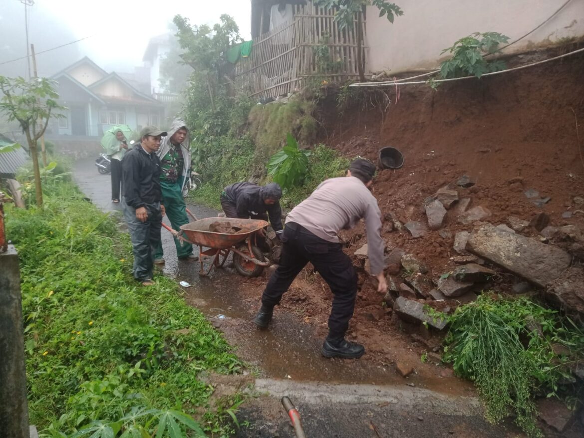Polsek Cihaurbeuti Bantu Warga Evakuasi Material Tanah Longsor yang Menutupi Jalan Dusun