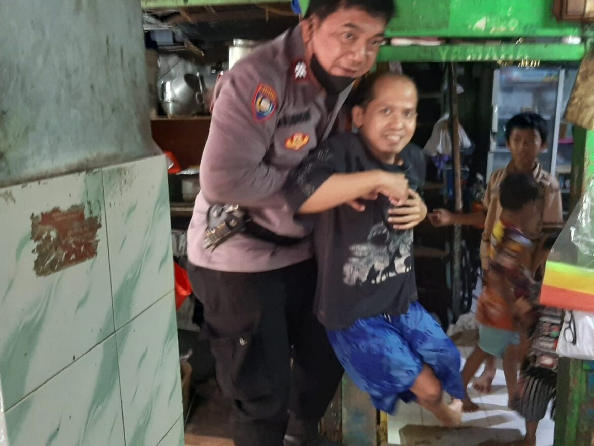 Babinkamtibmas Polsek Metro Taman Sari Aiptu A. Budiono Peduli Kemanusiaan Menggendong Warga Penyandang Cacat Menuju Puskesmas