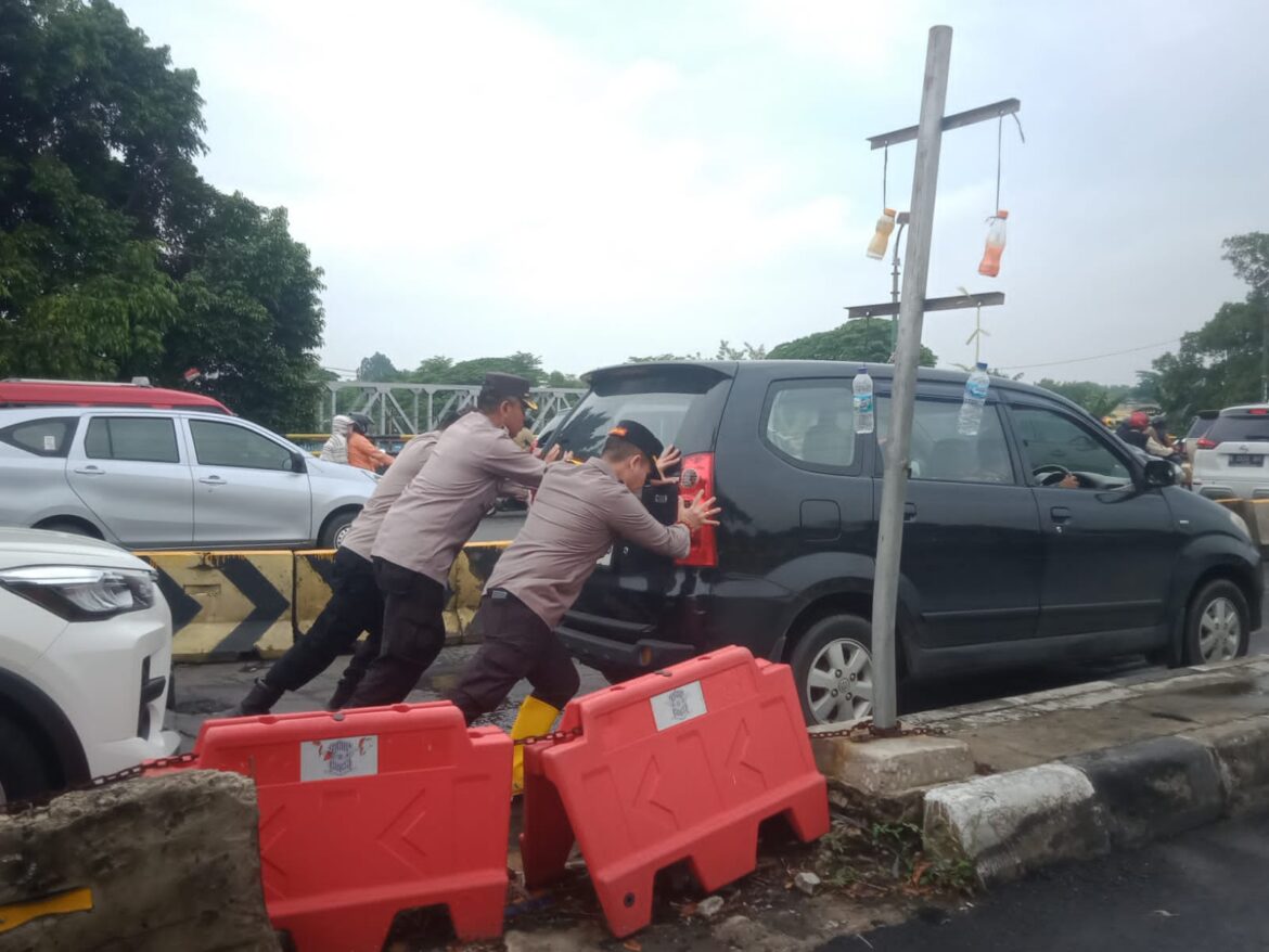 Personel Polsek Cengkareng Berjibaku di Tengah Banjir, Mendorong Mobil Mogok