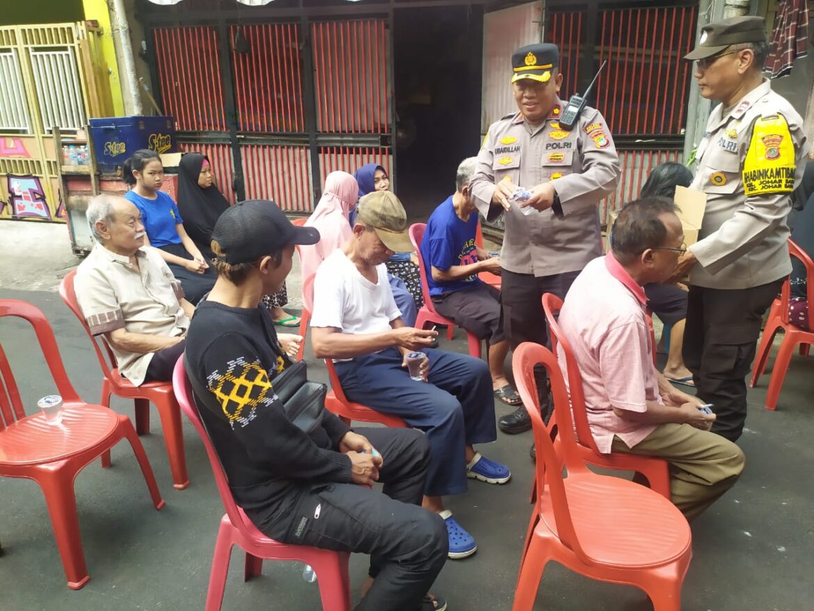 Kapolsek Johar Baru Memberikan Air Mineral Kepada Warga Menunggu Giliran Menerima Bansos