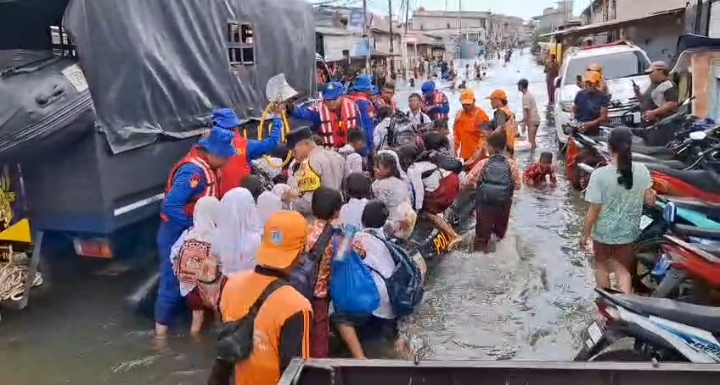Bhabinkamtibmas Muara Angke dan Ditpolairud Polda Metro Jaya Seberangkan Anak Sekolah di Lokasi Banjir