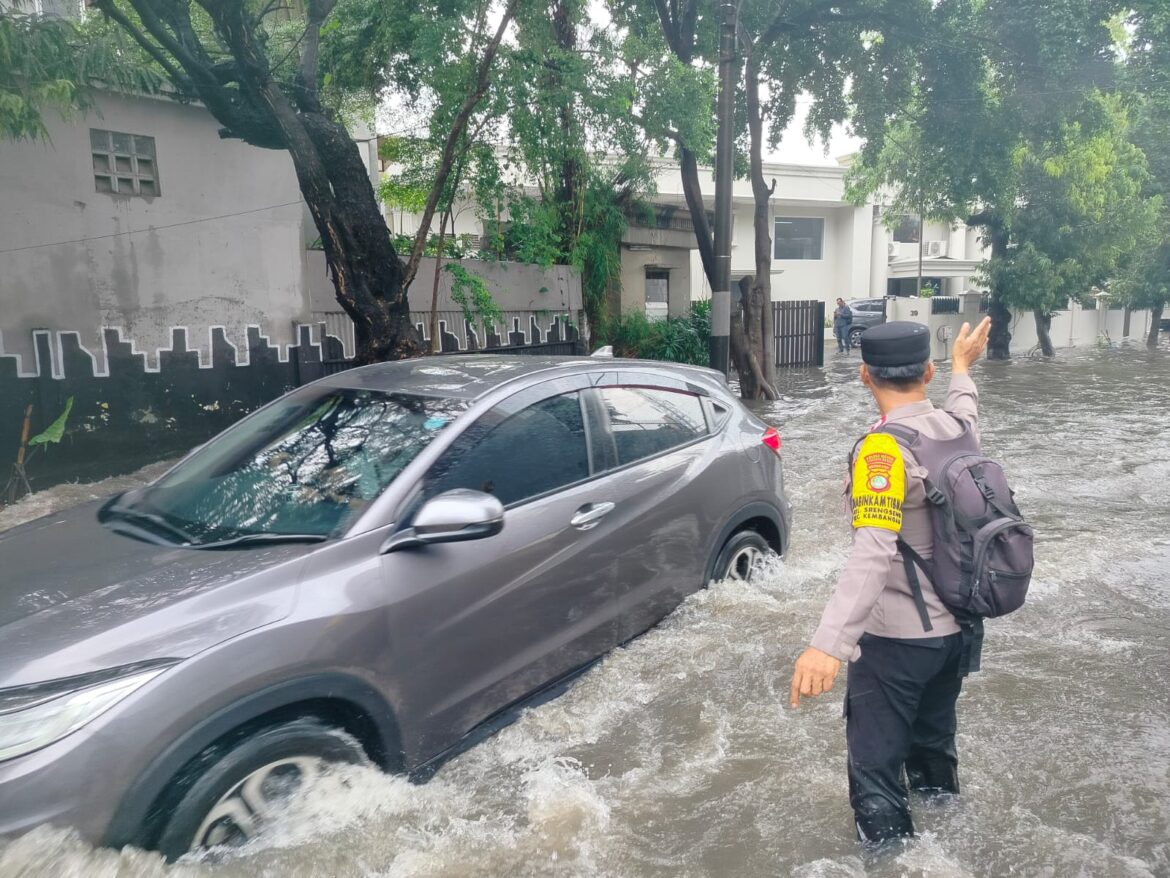Aksi Humanis Bhabinkamtibmas Srengseng Saat Hujan Deras Genangi Jalan Depan SDN 05 Kembangan
